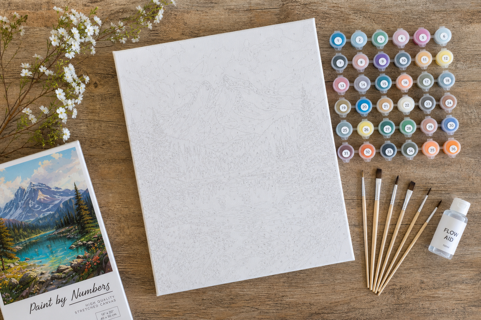 A beautifully arranged custom painting kit showing a stretched canvas, acrylic paints, and wooden brushes